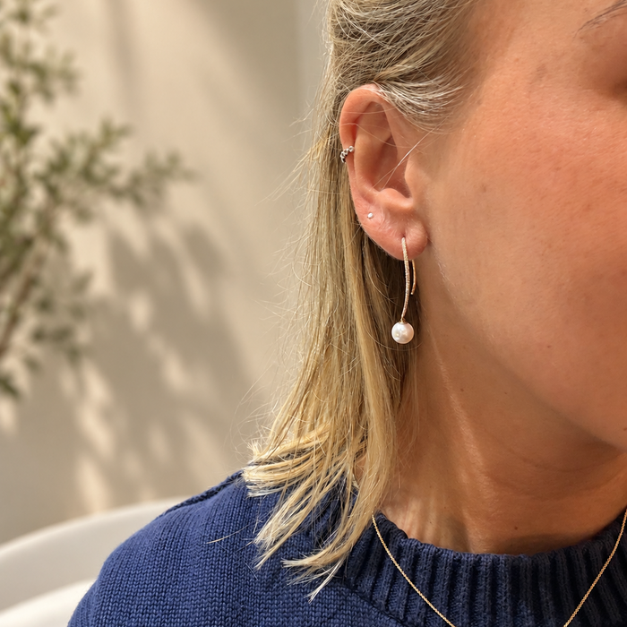 Parel en diamant doorsteekoorbellen in geelgoud