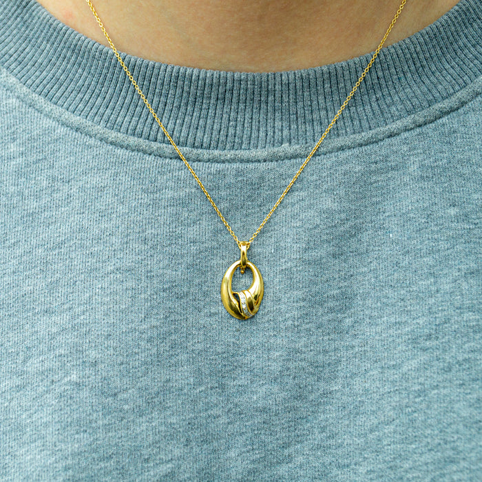 Gouden hanger met ovaal golvend design en zirkonen